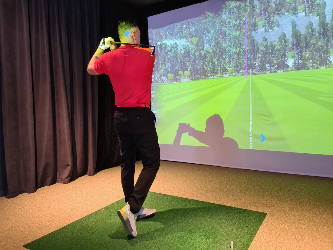 man playing a golf simulator